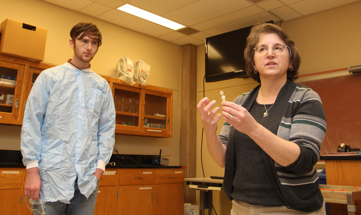 Honors biology professor Carolyn Wetzel talks to students during lab.