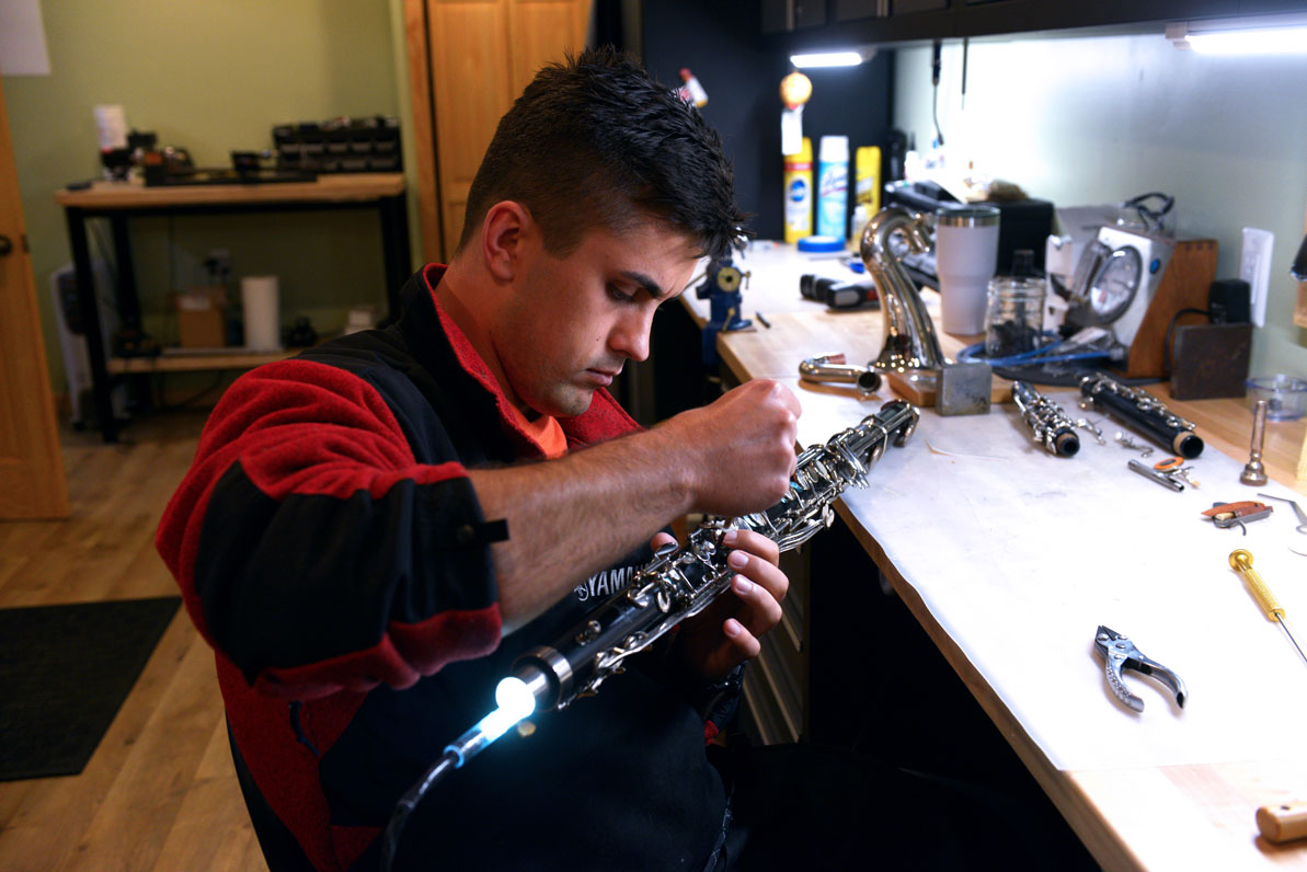 Filipp repairs a clarinet in the Dubchaks' basement workshop. 