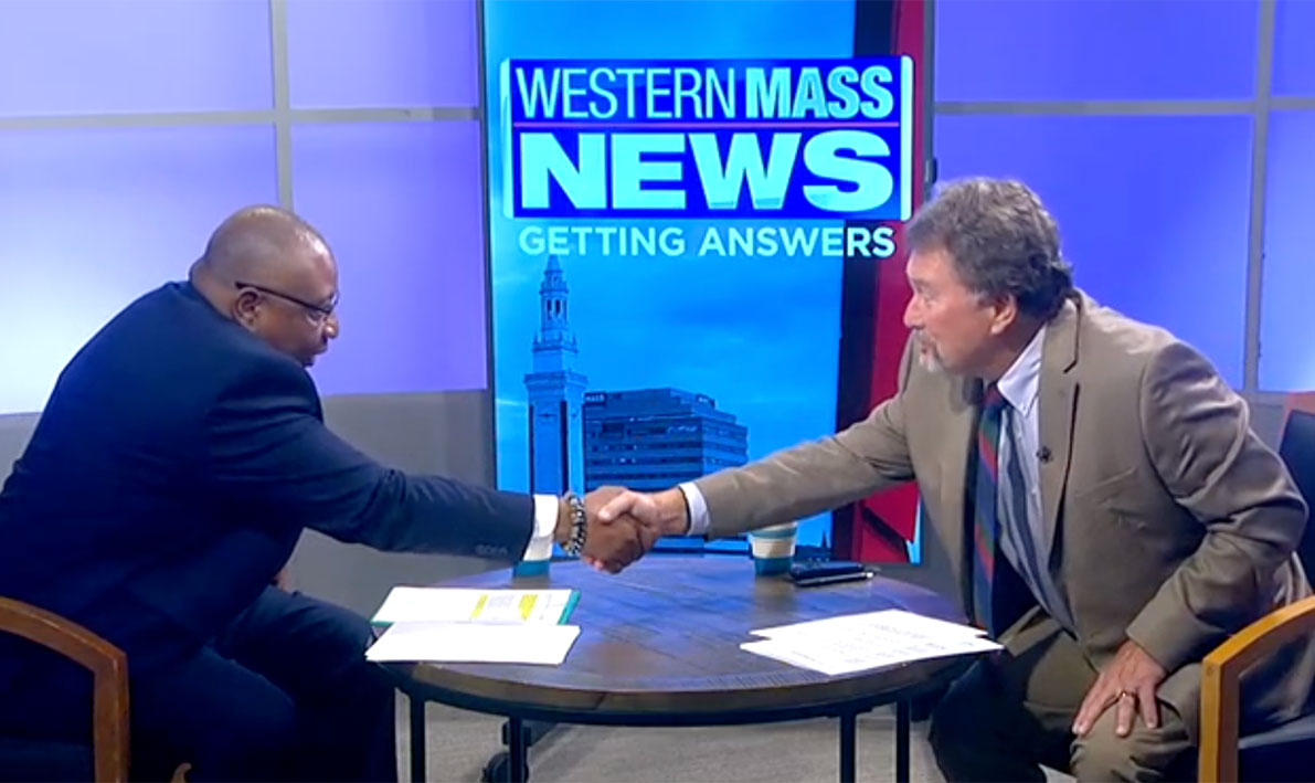 President George Timmons shakes hands with interviewer Dave Madsen.
