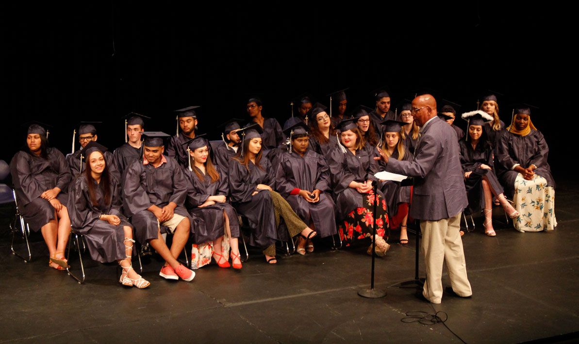 HCC professor Gaylord Saulsberry delivers a speech to graduates at HCC's Gateway to College June 7 graduation ceremony on the stage of the Leslie Phillips Theater.  