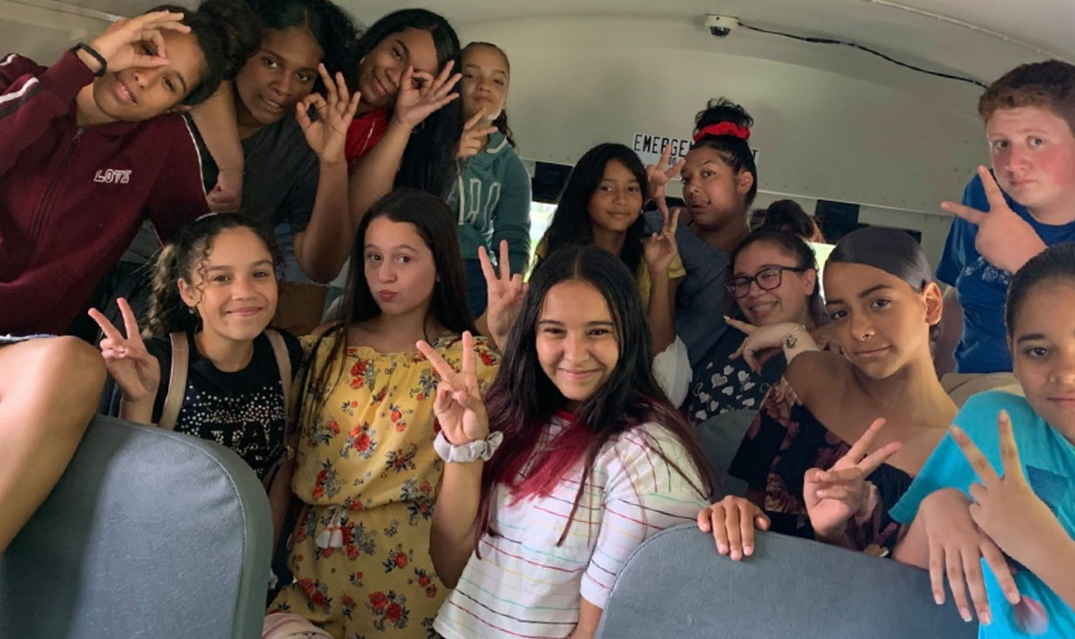 School age children goofing around on a school bus