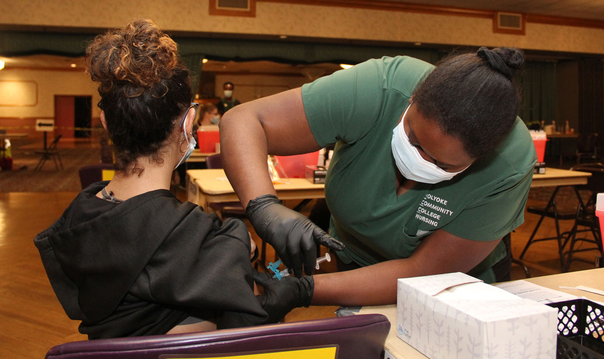 An HCC nursing student administers a COVID-19 vaccine