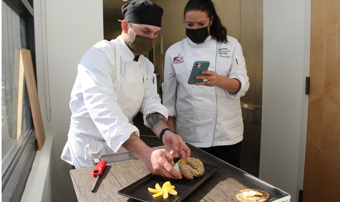 HCC student chef Kyle Rondeau prepares his bagel sandwich for a promotional photograph.