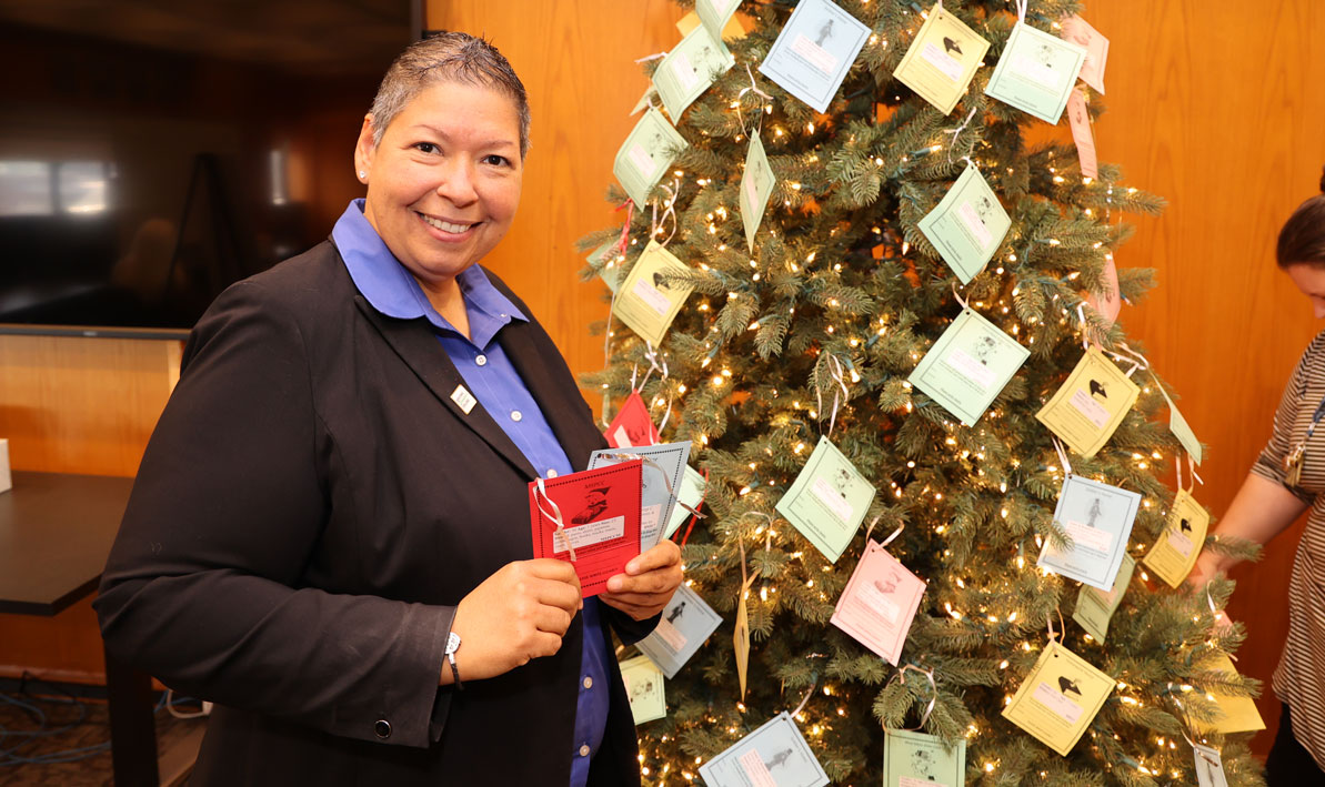 HCC President Christina Royal holds a few tags from the college's Giving Tree.