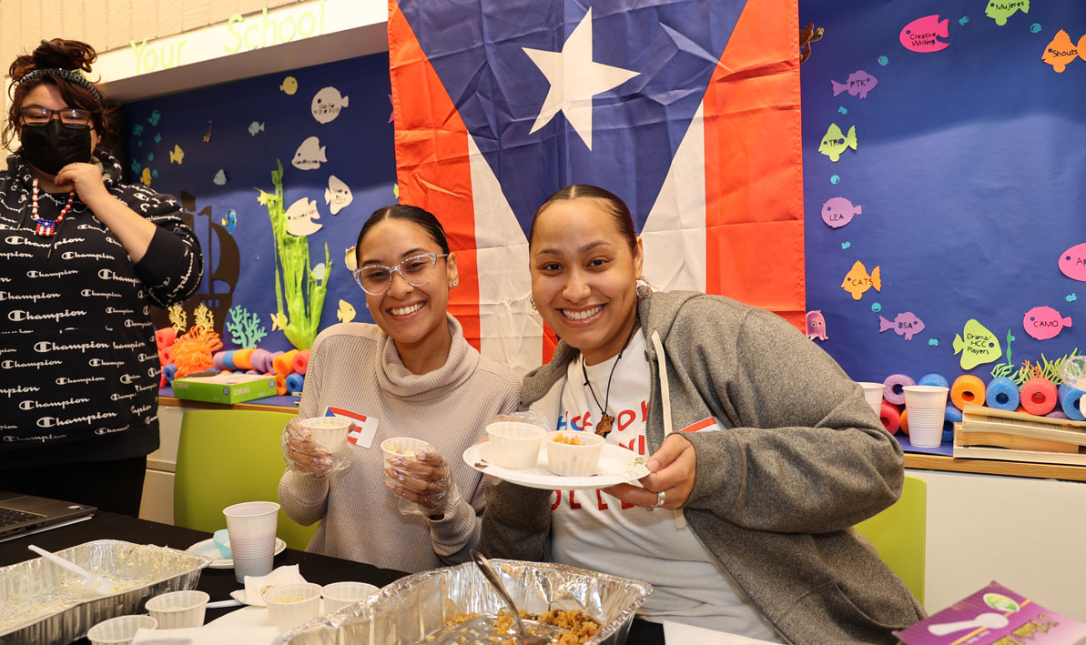 Staff from the El Centro program at Holyoke Community College celebrate Hispanic Heritage Month beneath a Puerto Rican flag during a campus fiesta on Oct. 5.