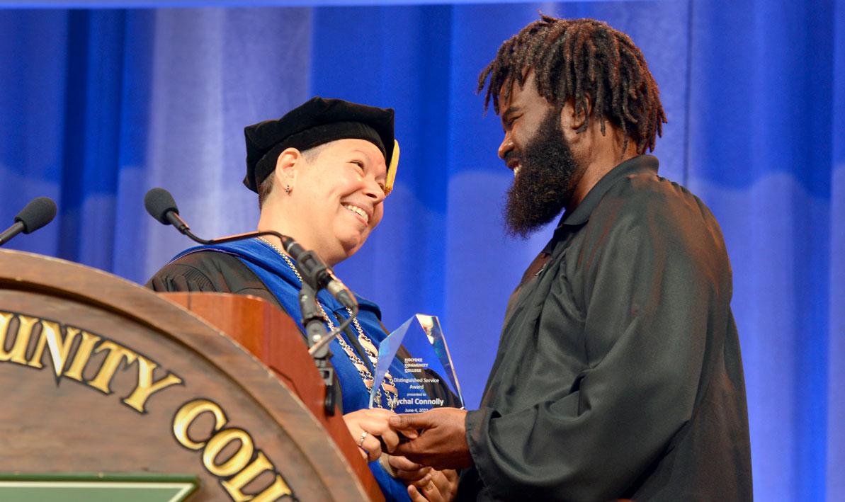 HCC president Christina Royal presents the 2022 DSA to alum Mychal Connolly '04.