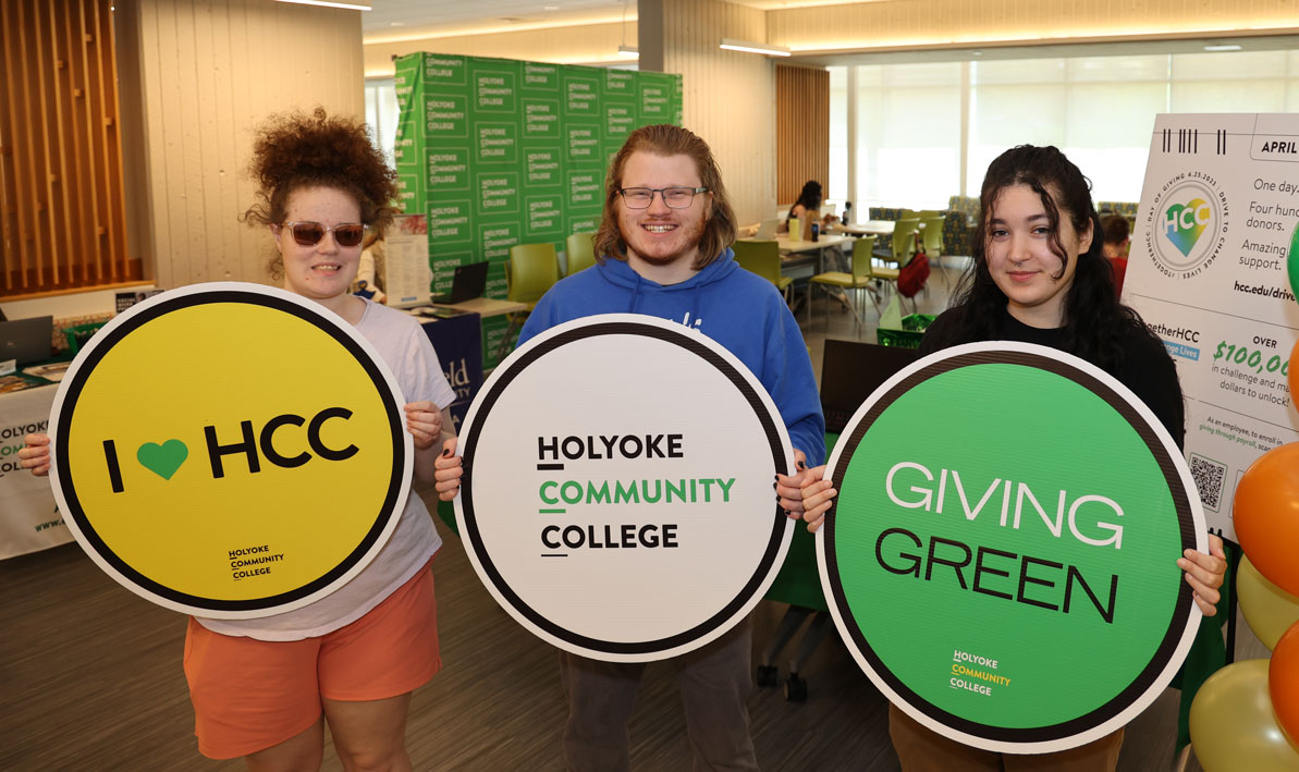 HCC students hold up signs promoting the college's one-day "Together HCC: Drive to Change Lives" campaign. 