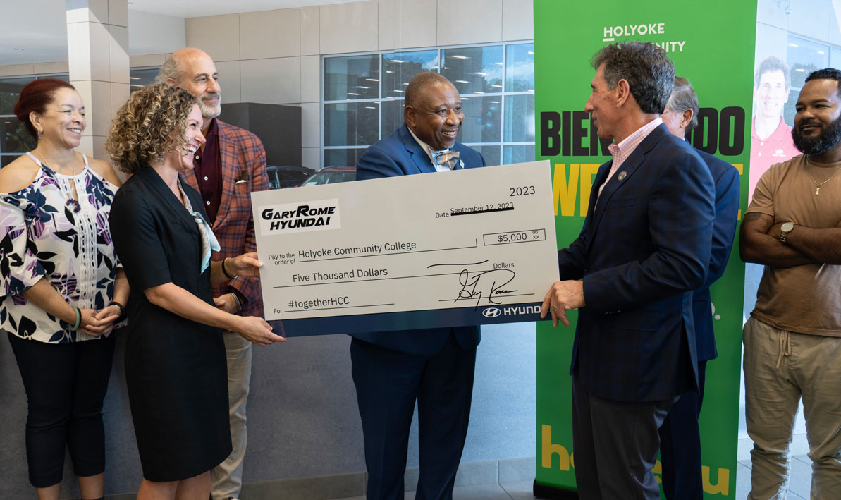 HCC President George Timmons, center, accepts a ceremonial $5,000 donation check from Gary Rome, right. (Amanda Sbriscia, HCC vice president of Institutional Advancement is holding the check on the left)