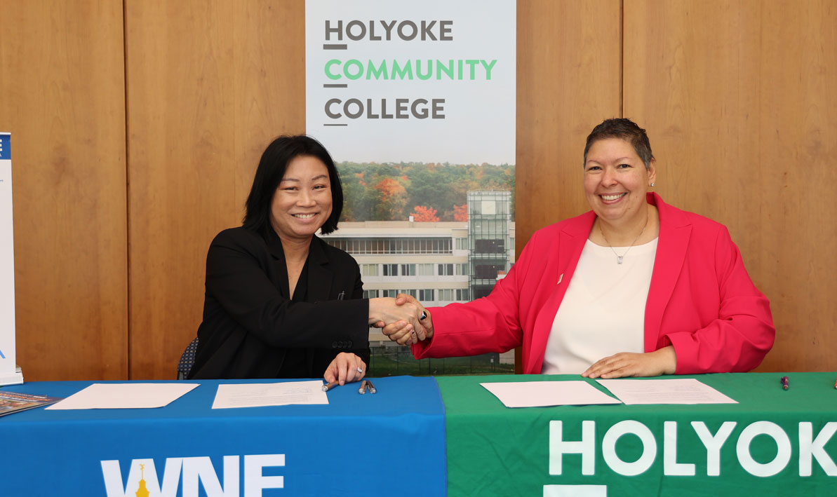 Maria Toyoda from WNE and Christina Royal from HCC sign a joint admissions agreement