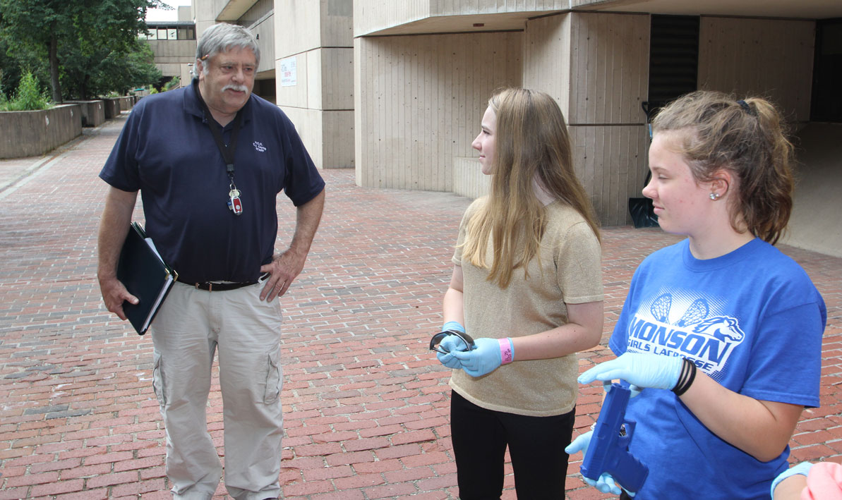 Instructor Lou Barry guides students through a mock crime scene investigation during a summer youth program. 