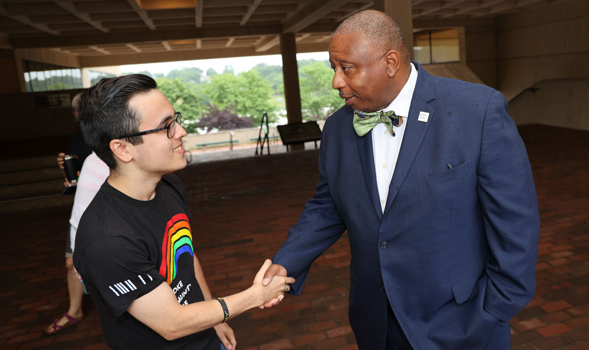 Student Trustee Barney Garcia shakes hands with HCC President George Timmons.