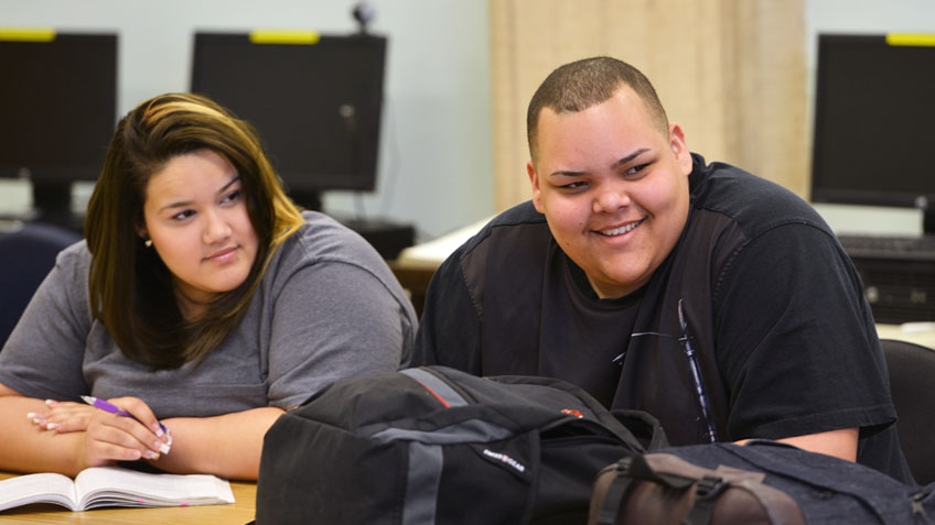 Two students smile in a classroom