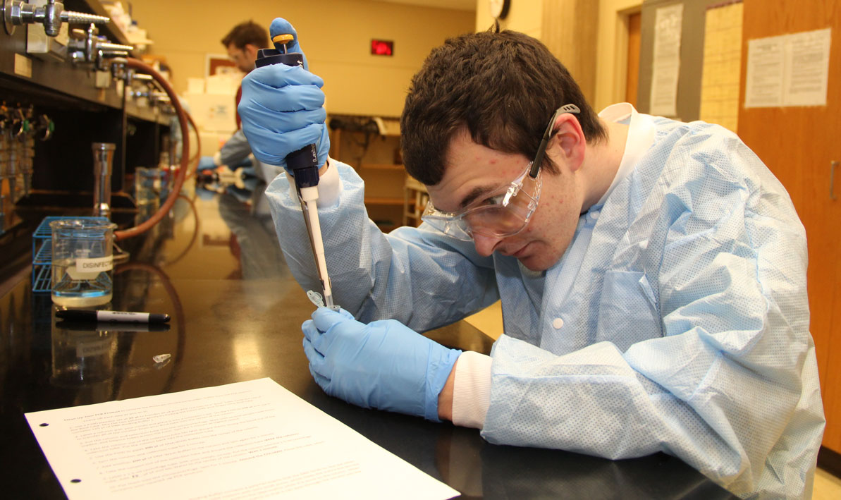 HCC honors biology student Justin Roberts of South Hadley uses a micro-pipette to deposit strands of DNA into test tube.