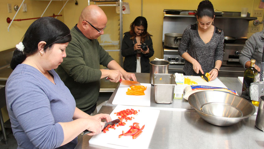 Program participants dice peppers for a rice dish.