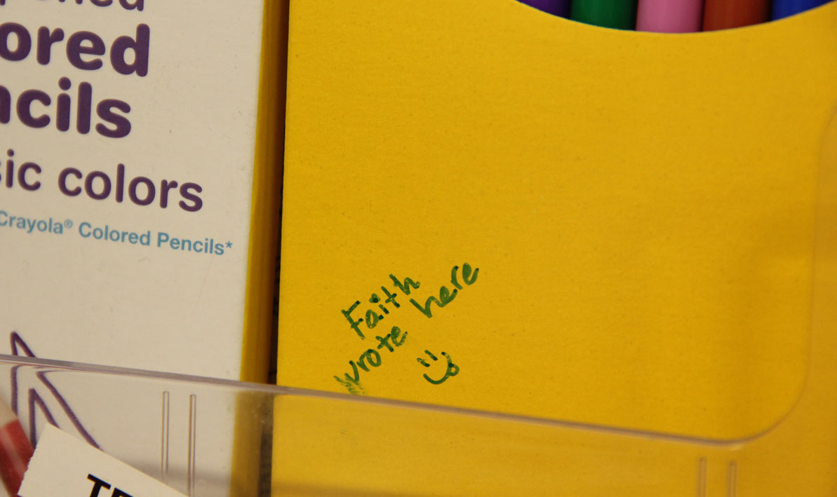 Faith Wrote Here, on a yellow box of colored markers