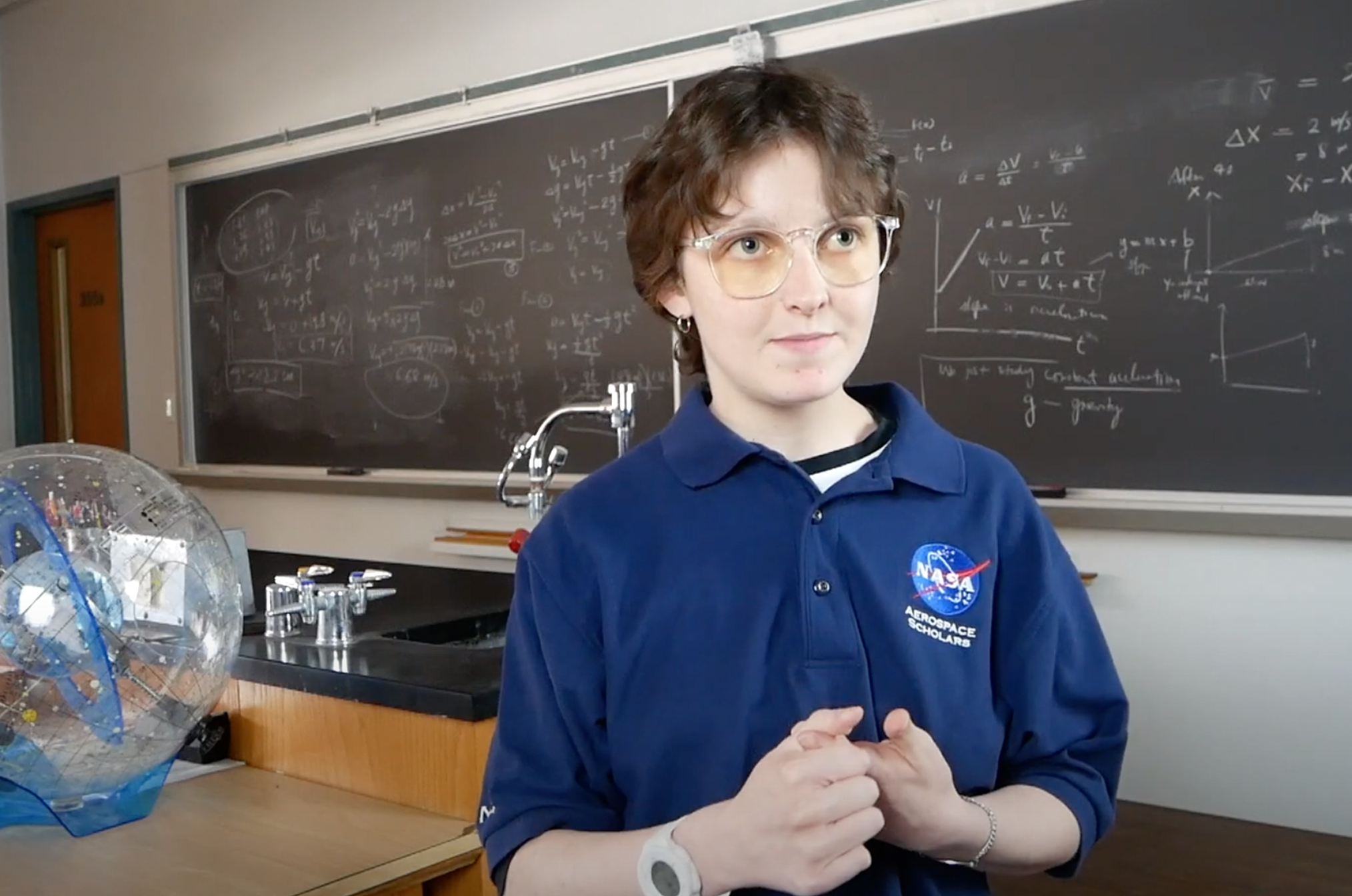 Eva Sweeney wears a NASA polo in a classroom