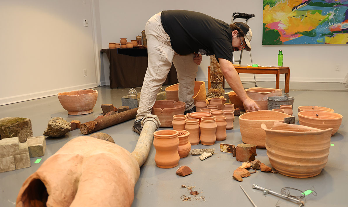 Artist Michael Madeiros installs his work for Taber Art Gallery exhibit.