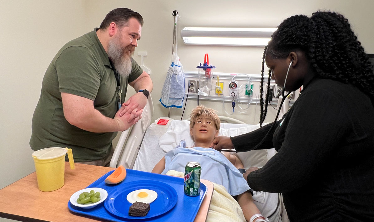 A student from Springfield Central High School examines a patient at the Centr for Health Education & Simulation.
