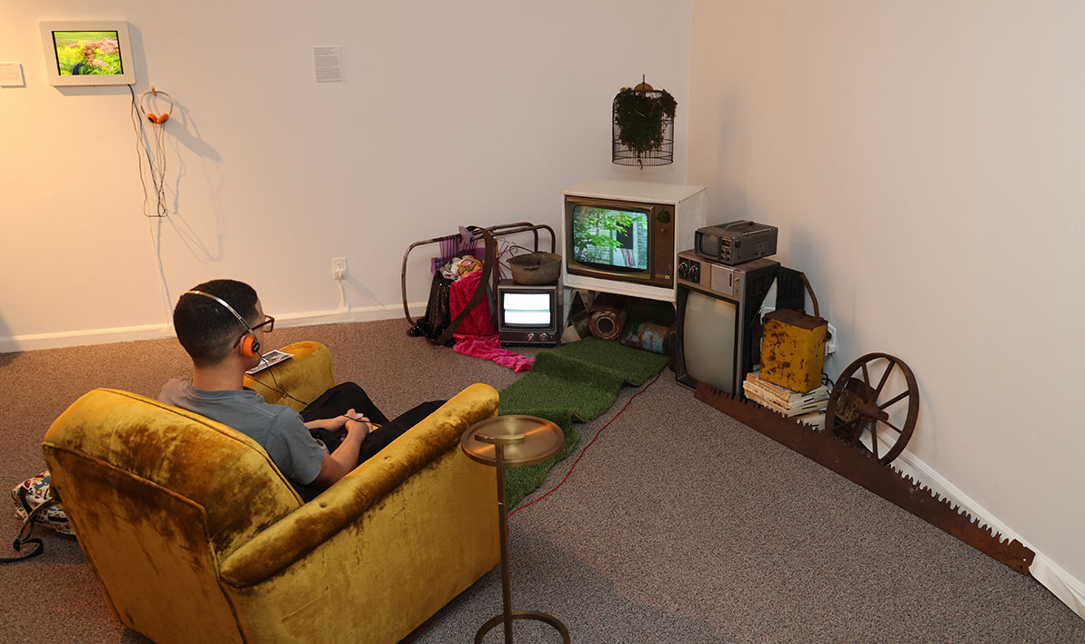 A student watches a short film in HCC's Taber Art Gallery. 