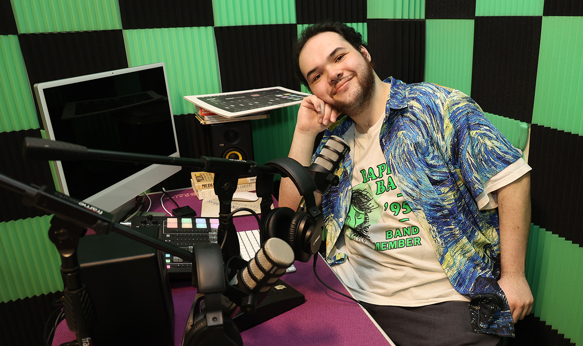 Student John Scully, in the HCC Podcast room, with a mic